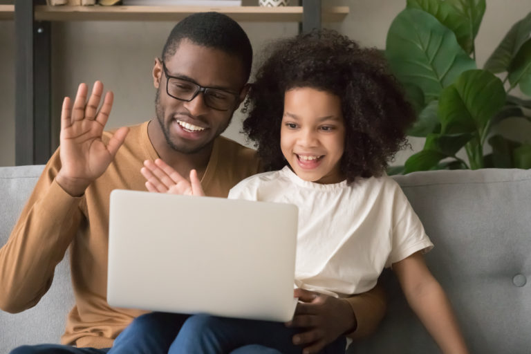 Happy black dad with kid daughter waving hands making videocall