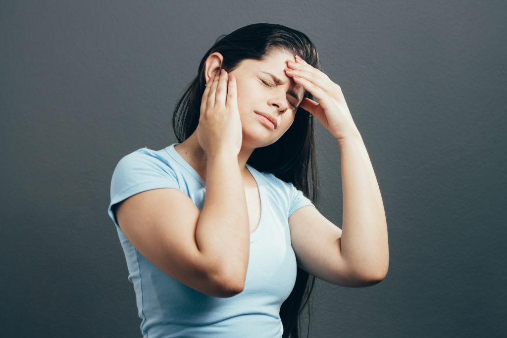 Young woman with ear pain, holding hand on her head