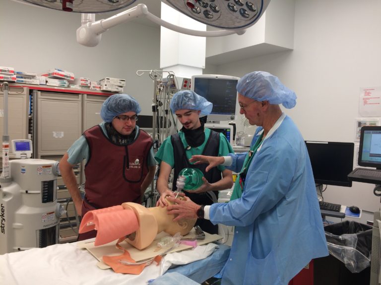 CMSRU students Michael Springer (left) and Geoffrey Kelly (center) in the OR with Dr. Edward Deal.