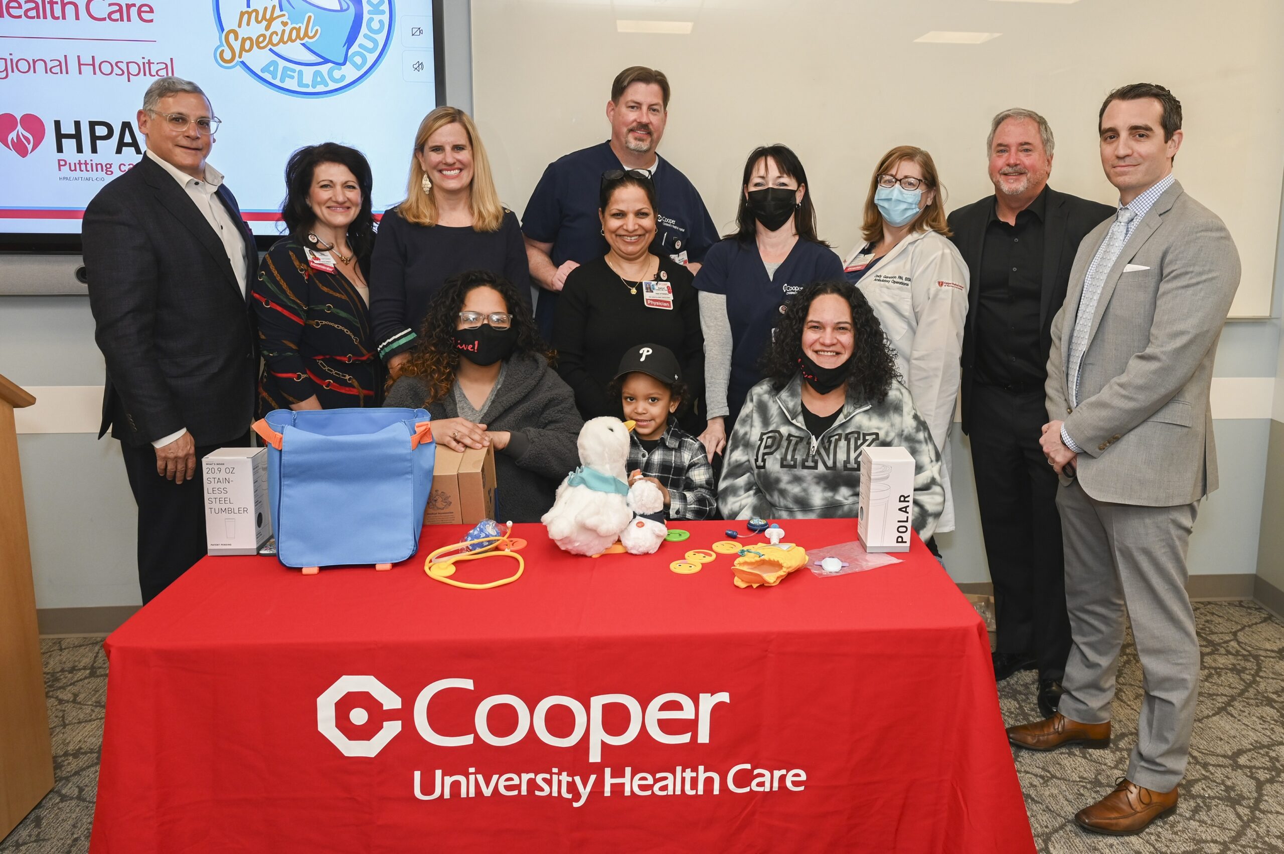 Cooper University Health Care and both local and national Aflac representatives surround four year old Tristan Cruz, his family, and his new My Special Aflac Duck. 