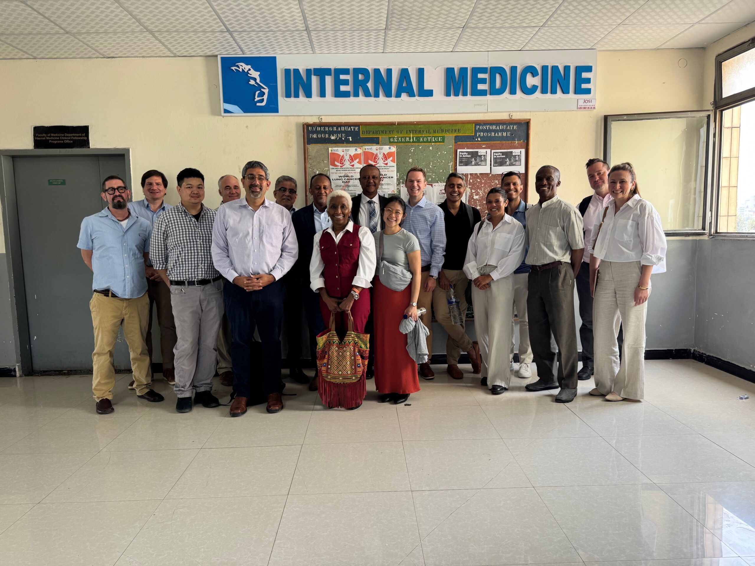 A group of people stand facing the camera and smiling under a sign that reads "Internal Medicine"